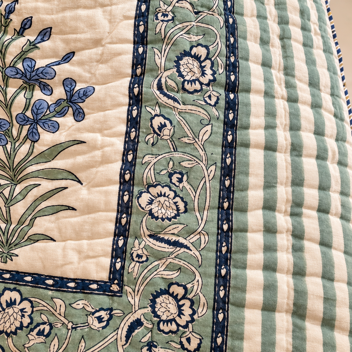 Nilgiri quilt border detail with green-blue floral vine and striped edge