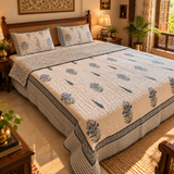 Nilgiri sage and blue hand block printed cotton quilt on bed