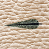 Close-up of Nilgiri quilt sage leaf motif on quilted cotton