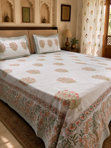 Orange and green motif hand block printed cotton king bedsheet on bed